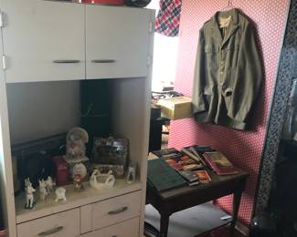 side table, books, military uniform, white cabinet (for kitchen?)