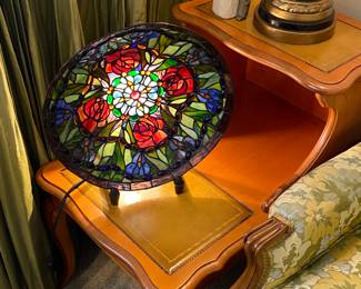 Stain glass bowl on lighted stand.
One of a pair of leather top end tables