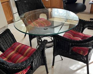 Wicker table with glass top and three matching chairs 