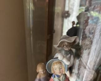I have to remove these from the curio cabinet. In the foreground is “Spring Morning” by Royal Doulton. The figure in the purple is also Royal Doulton “Marie.”