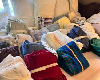 Several sets of sheets and mattress pads