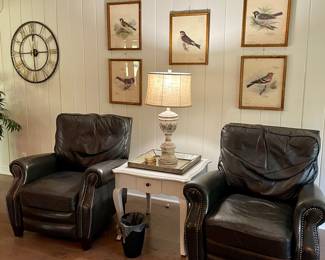 Pair of leather dark gray relcliners, 6 reproduction framed bird prints, white end table, large decorative wall clock, distressed wooden lamp