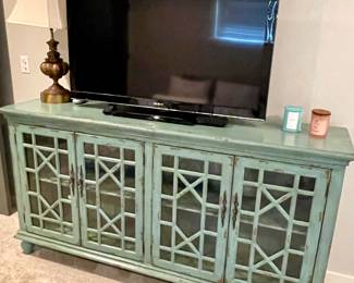 large console cabinet, flat screen TV, metal lamp