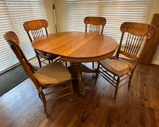 42" round wood table (shown with one leaf in table and another leaf against the wall) with 4 cane chairs 