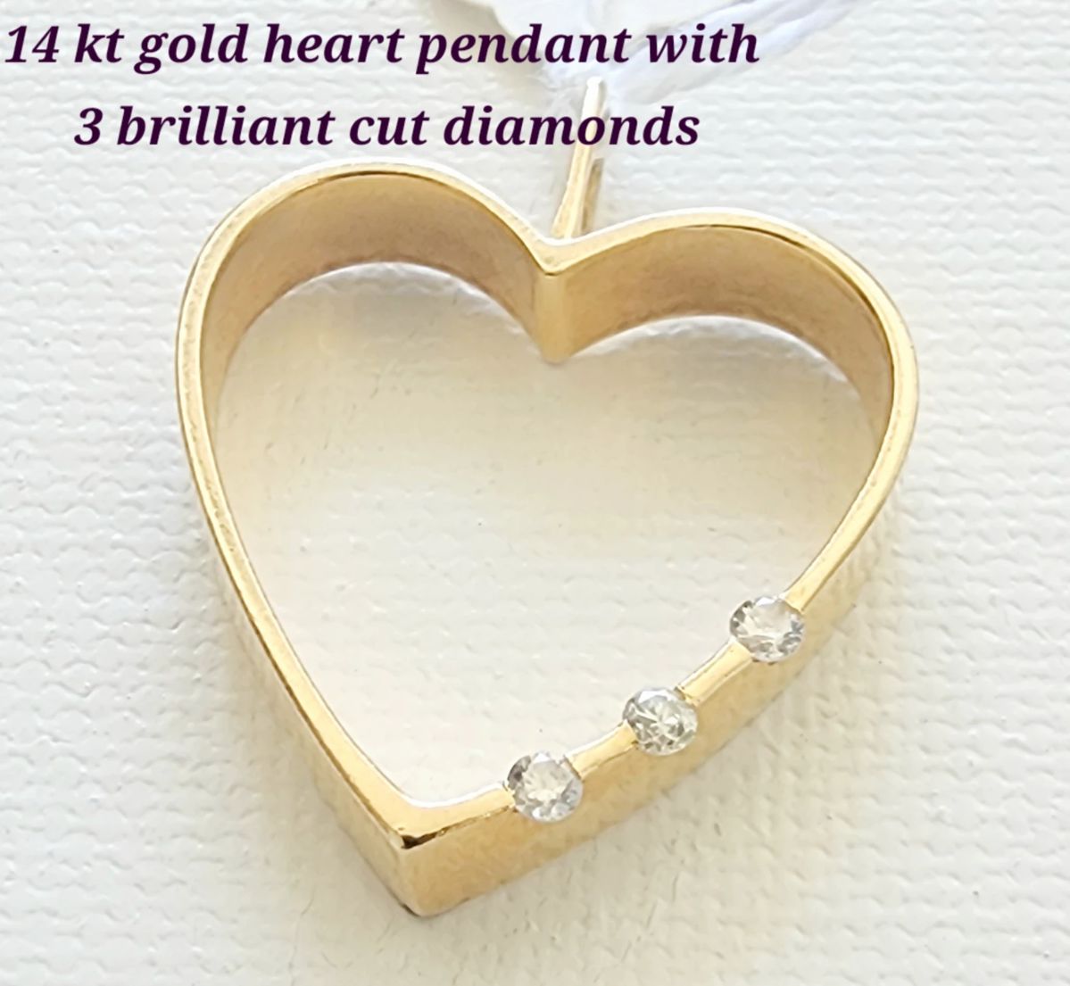 14 kt gold heart pendant with 3 brilliant cut diamonds.