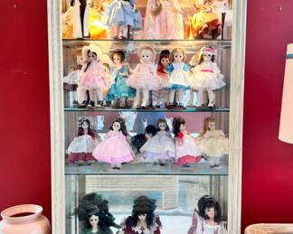 One of two cream-colored wood/glass display cases. Madame Alexander dolls, collectible Barbie dolls, and Scarlett O'Hara and Audrey Hepburn dolls