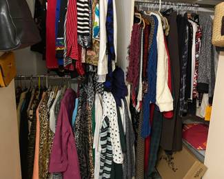 Closet loaded with nice clothing and shoes.