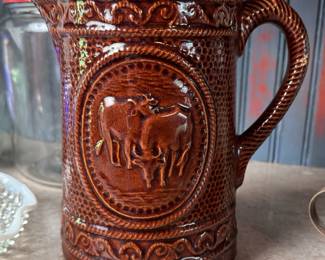 Brown glaze stoneware pitcher with horned cows, long intact hairline on side 8"H