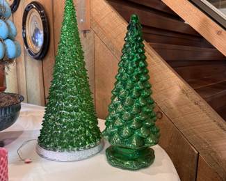 Two green plastic battery-operated trees, one is musical 20"H