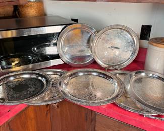Group of silvered and silver-plated serving trays, some wear, largest is 18"