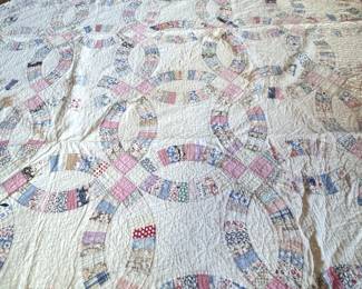 Double wedding ring quilt with intricate floral stitching, one edge has some thinning and small holes, 90" x 74"