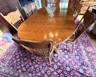 Antique oak dining table with winged paw feet at each end, central pedestal support, 8 carved back spindle chairs with similar backs (some chairs have wear and seat repairs, 4 leaves, 94" with leaves & 53" without, 54"W