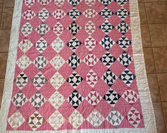 Triangles scrap quilt with pink background, minor spots 62" x 72"
