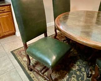 green leather chairs with round dining table