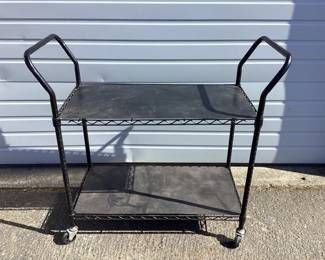 NOBE708 Black Metal Cart A two tiered black metal cart on wheels. Includes plastic covers for each shelf. 
