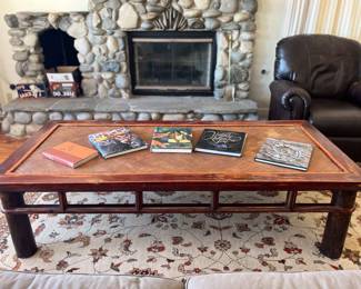 large asian coffee table, coffee table books, handmade wool rug, leather easy chair