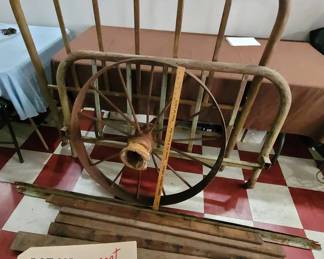 large cast iron wagon wheel and iron bed with rails and slats