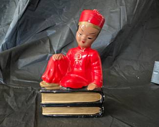 Japanese person sitting on books collectibles statue