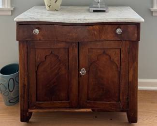 Antique Mahogany Marble Top Two-Door Cabinet with Serpentine Drawer and Glass Pulls. Measures 33" W x 16" D x 29.5" H. Photo 1 of 2.