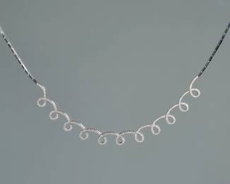 DIAMOND & 18K WHITE GOLD SPIRAL LINE NECKLACE | having eleven articulating loops mounting a continuous line of melee diamonds set in 18k white gold, box clasp with two security latches; marked "750" . total weight 18.6g. - l. 15 in. (approx.)
