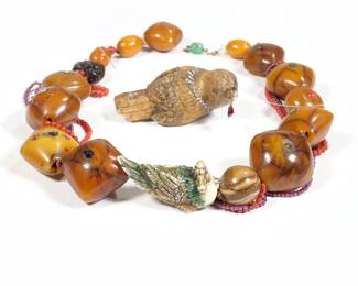 UNUSUAL ASIAN CARVED BIRD & JEWELED AMBER NECKLACE | Chinese or Japanese; Designed as variously shaped large amber beads (34 x 37 x 25 mm., largest) each mounting smaller semi-precious gemstones including moonstone, coral, opal, ruby, etc., plus a smaller selection of carved and other beads; 20 in. Total weight 171.8g

