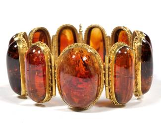 ANTIQUE AMBER TOURMALINE LINK BRACELET | having ten well-matched links of oval amber tourmaline cabochons (29 x 12 x 7 in., each approx.) and one central cabochon (30 x 22 x 9.8mm) each in a gold ropework surround with coiled hinge links
7 in., 79.5g
 - l. 7 in.
