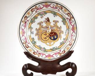 CHINESE ARMORIAL CHARGER | Decorated with boars, garlands, and heraldic devices, gilt highlights, on a conforming carved wood stand
dia. 14.25 in.

