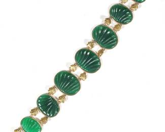 CARVED SPINACH JADE & 14K GOLD BRACELET | Designed as 8 links of oval shell-pattern carved jade plaques (23 x 17 mm, largest) mounted in gold surrounds and connected with gold loops, marked "14k"; 20.7g. - l. 7 in.
