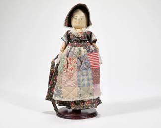 ANTIQUE WOODEN DOLL | Hand-painted and carved wooden doll with quilt apron and articulating arms
 - l. 5 x w. 2 x h. 11 in.