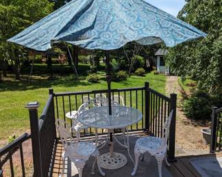 Round metal outdoor table with umbrella. Set of 3 cast iron chairs and loveseat.