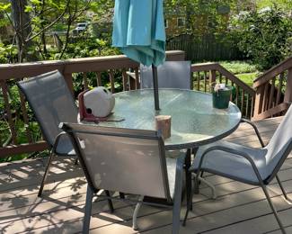 Patio table and four chairs and umbrella.