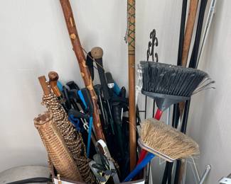 Assorted canes, walking sticks and cleaning supplies.