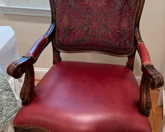 Red leather seated chair with decorative fabric seat back. 