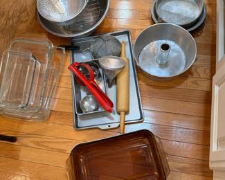 Group of glass baking pans, cookie sheet, roller, large bowl, strainers