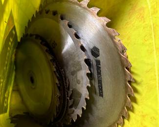 Yellow bucket of assorted saw blades, used