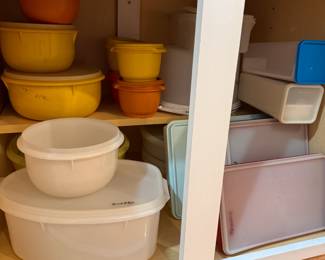 Cupboard of vintage plastic storage, the majority is Tupperware, a few do not have lids