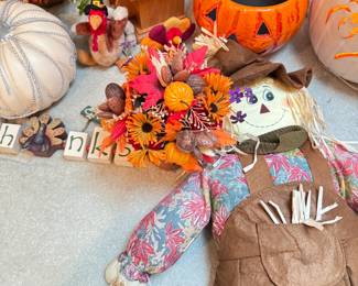 Group of fall decorations including lighted pumpkin and scarecrow 