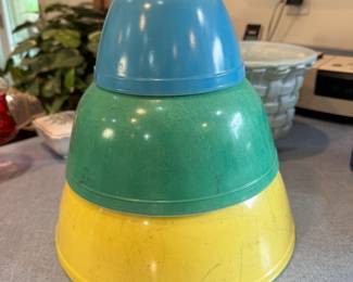Three Pyrex vintage bowls, yellow shows the most exterior marks, green also has exterior marks, blue is in nice condition