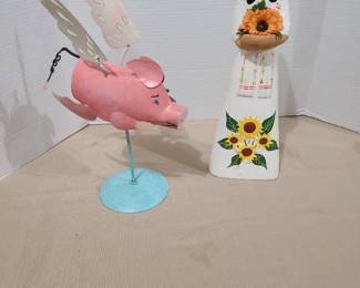 Woman with sunflower 15 inches tall and flying pig on stand.