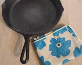 12 inch Lodge brand cast iron skillet with kitchen towel.