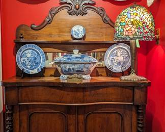 Antique English sideboard, with mirrored back, barley twist columns and carved top apron, collection of blue/white porcelain plates, platters and tureen and Tiffany style stained glass table lamp. 