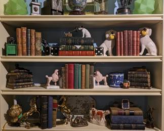 One of two built-in bookshelves filled with vintage and antique books, bronze figures, vintage porcelains, light globes, cast iron toys, etc. 