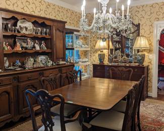 Beautiful dining room, with 1940's banded mahogany dining table, with two leaves, by Cassard, Romano Co., Inc., NYC, antique French oak hutch, 1940's mahogany buffet, by Drexel, antique English crystal chandelier, from 1900, segmented wall mirror,  pair of cloisonne table lamps, Persian Heriz rug atop a sisal rug and four sets of china. 
