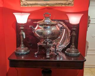 Antique English pencil inlay mahogany game table, with pair of bronze table lamps, with green marble base, pink milk glass shades, vintage three-piece silver plated hotel samovar and original fruit still life, by listed English artist, Thomas C. Bale.