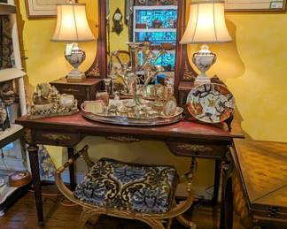 Beautiful antique writing desk, with bronze ormolu, w/ matching adjustable beveled glass mirror and 6 storage drawers, pair of vintage earthenware table lamps, with shades, finials, vintage English silver plated gallery tray with collection of beveled glass boxes, Queen Nefertiti dressing chair and set of 4 nicely framed/matted botanicals.  