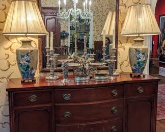 1940's mahogany buffet, by Drexel, pair of large cloisonne table lamps, pair of large English silver plated candlesticks, pair of sterling silver repousse vases, pair of Tiffany silver plated wine coasters and segmented wooden wall mirror.