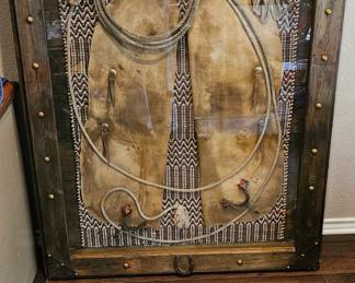 Very unusual cowboy chaps with lasso in wood frame.  Measures 42" x 55"