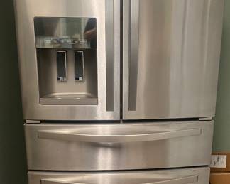 Whirlpool stainless steel refrigerator with drawer freezer. Has dents but works great 