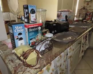 New in boxes kitchen gadgets, toaster, hot dog grill, colored serving dishes.