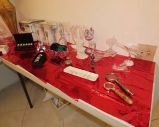 Stemware, magnifying glasses, decorative teaspoons, crystal birds, and perfume bottle.